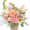 Pink and peach floral arrangement in a ribbed glass vase