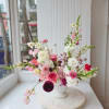 Pink and white mixed flower arrangement in a white vase