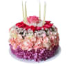 Round floral cake with pink and purple flowers and tall candles
