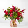 Bouquet of red and pink flowers in a pink glass vase
