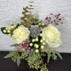 Cream rose arrangement with berries and eucalyptus in a vase