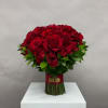 Bouquet of red roses with green foliage tied at the stems