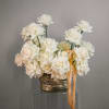 White rose bouquet in a metallic vase with a gold ribbon