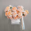 Peach roses arranged in a white vase with a Dior ribbon