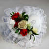White satin ring pillow with red and cream roses