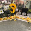 Sunflower and daisy arrangements in mason jars on a tray with sunflower ribbon