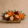 Autumn floral arrangement with orange lilies, roses, pumpkins, and berries in a gold container