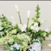 White calla lilies and pale green orchids in a low floral arrangement