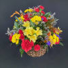 Mixed bouquet in a woven basket with red, yellow, and purple flowers