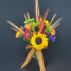Bright mixed bouquet with a sunflower in a glass vase and striped ribbon