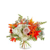 Fall bouquet with white hydrangeas, a blush rose, and orange mums in a glass vase