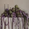 Artichoke centerpiece with purple ribbons and tall black candles