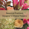 Pink lilies, peach roses and green hydrangeas with overlaid text reading Seasonal Premium Designer’s Choice Flowers.