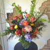 Mixed bouquet of roses, hydrangeas, and chrysanthemums in a glass vase
