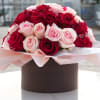 Bouquet of red and pale pink roses wrapped in blush paper