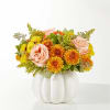 Pink roses and yellow-orange mums in a white pumpkin vase