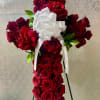 Cross-shaped arrangement of red roses with a white bow