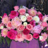 Pink and white rose bouquet with dahlia-like blooms in a clear vase