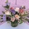 Pastel bouquet of roses, tulips, and lisianthus in a glass vase