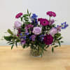 Mixed purple bouquet in a clear glass vase