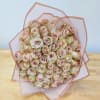 Bouquet of pale pink roses wrapped in translucent pink paper