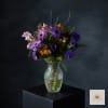 Purple and pink mixed bouquet in a clear glass vase
