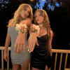 Two women wearing floral wrist corsages at an outdoor evening party.