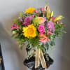Mixed bouquet with sunflowers, roses, lilies, and purple mums in a vase