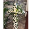 White floral standing cross on an easel