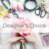 Hands holding pink flowers with floral tools and wire on a white table