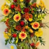 Tall easel spray of warm gerbera daisies, mums, Bells of Ireland and