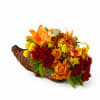 Orange and red flowers arranged in a wicker cornucopia basket