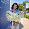 Woman holding a large heart-shaped bouquet of white and blush flowers