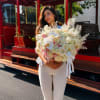 Woman holding a large bouquet of white and blush flowers