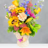 Colorful mixed bouquet in a cream vase with butterfly accents