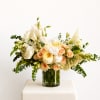 Cream and peach floral arrangement in a clear glass vase