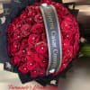 Large round bouquet of red roses with rhinestones, black wrapping, and a printed proposal ribbon.