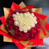 Large round bouquet of red and white roses with jeweled centers, wrapped in red and gold paper