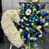 Standing sympathy easel with a white chrysanthemum heart and blue and white floral spray.