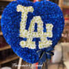 Heart-shaped blue and white floral standing spray with a monogram design and blue ribbon bow.
