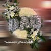 Oval funeral spray reading DAD in silver roses on white mums with white lilies and black accents.