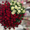 Large heart-shaped arrangement of red roses with white lilies and gerberas on one side
