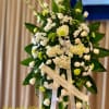Tall standing spray of white and green flowers with ribbons on an easel