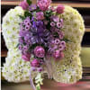 Sympathy pillow of white mums with central spray of lavender roses and daisies, finished with a purple ribbon bow.