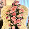 Angel wing-shaped white mum spray with pink roses and gerbera daisies on an easel
