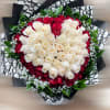 Round bouquet of cream and red roses with baby's breath, wrapped in black and white patterned paper.