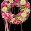 A beautiful sympathy wreath filled with soft pinks, whites, and greens&mdash;featuring roses