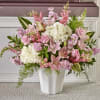Large pink and white arrangement with lilies, roses, and hydrangeas in a white vase