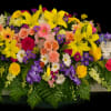 A radiant casket spray filled with vibrant lilies, roses, daisies, and more&mdash;this