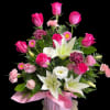 Pink and white arrangement with roses, lilies, and carnations in a pink vase with ribbon